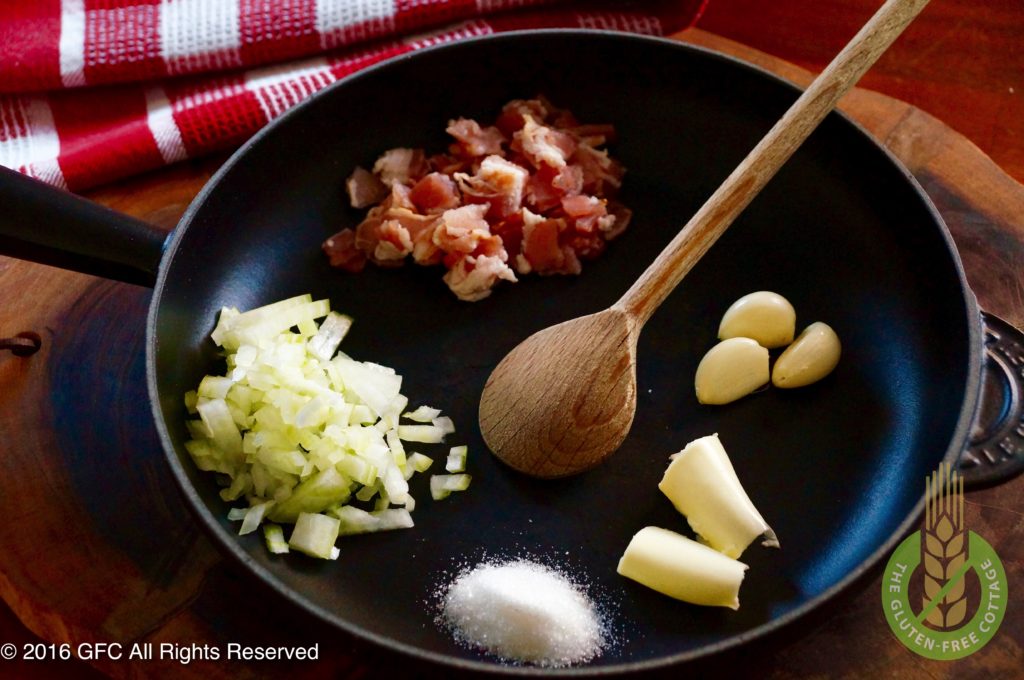 Frying bacon, onions and garlic over medium heat (gluten-free quiche Lorraine).