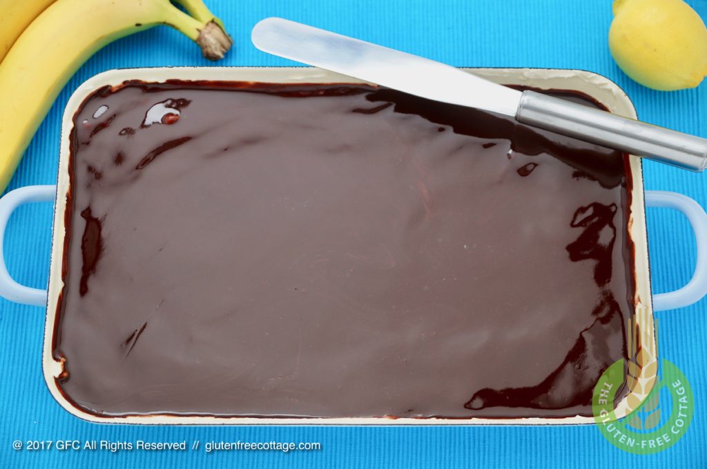 Freshly applied chocolate glaze (gluten-free banana cake with chocolate glaze).