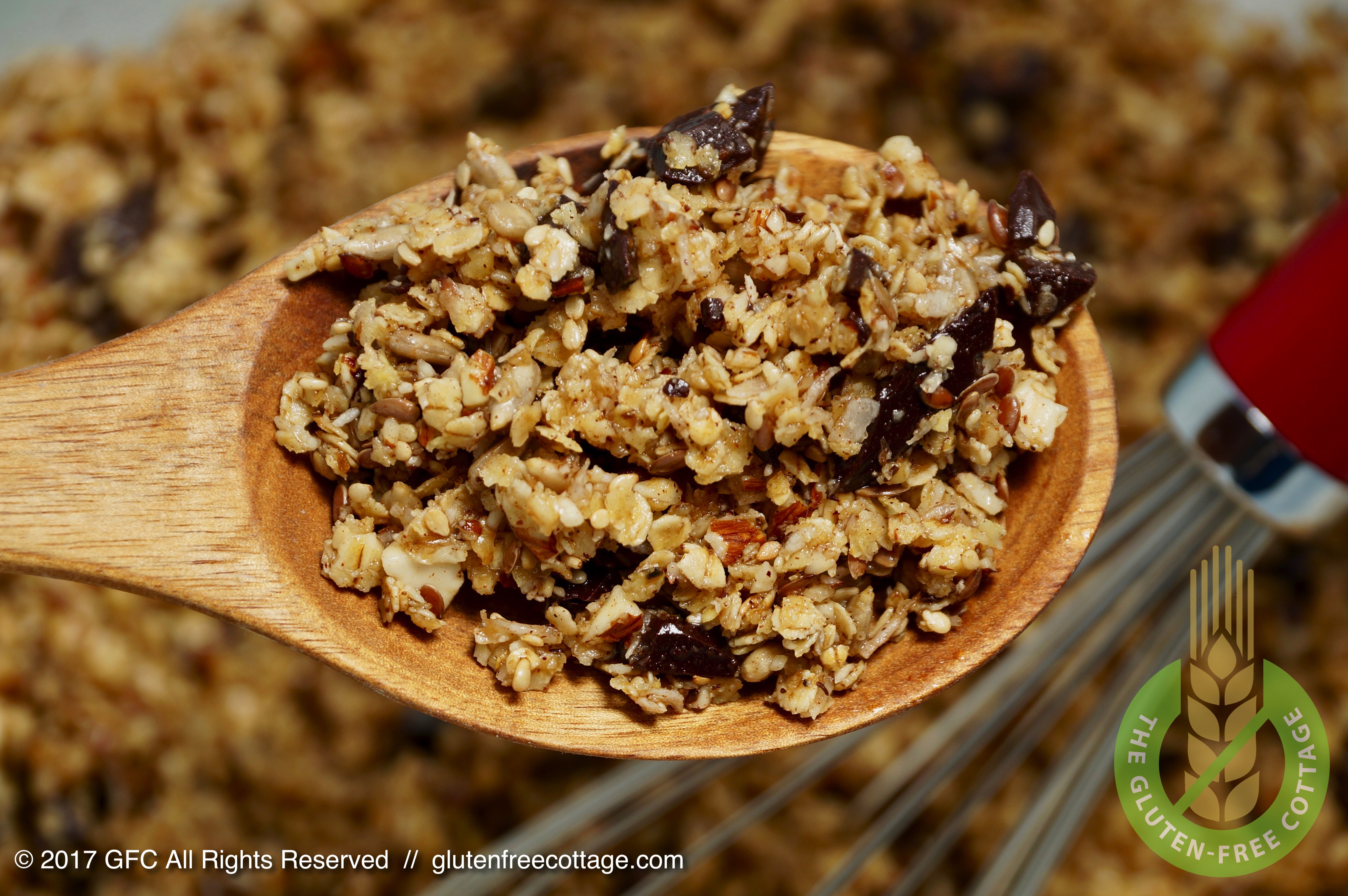 Raw granola dough on a wooden spoon (gluten-free granola cookies).